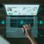 Laptop auf einem Schreibtisch mit einer eingeblendeten Grafik eines digitalen Netzwerks und Avataren zur Visualisierung von Social-Commerce-Strukturen.