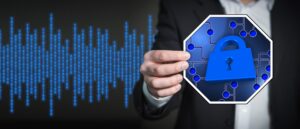 A hand holding a blue stop sign symbol with a padlock on a circuit board in front of a blue binary code background.